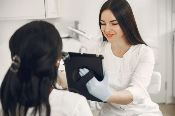 Esteticista mostra informações em um tablet para uma cliente durante consulta em clínica de estética